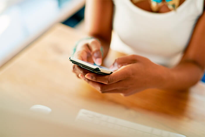 mulher digitando no celular para encontrar clientes no instagram