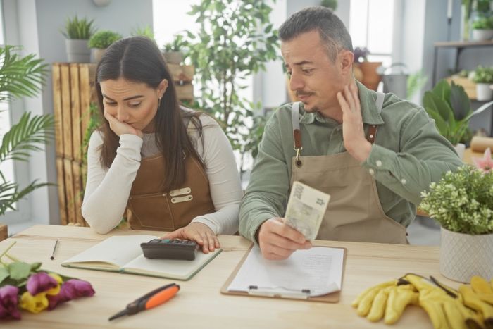 homem e mulher calculando métricas financeiras