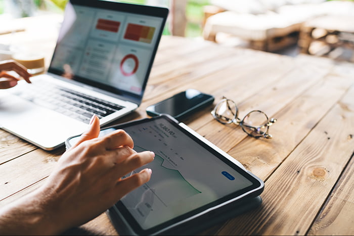 pessoa utilizando tablet e notebook para fazer precificação dinâmica