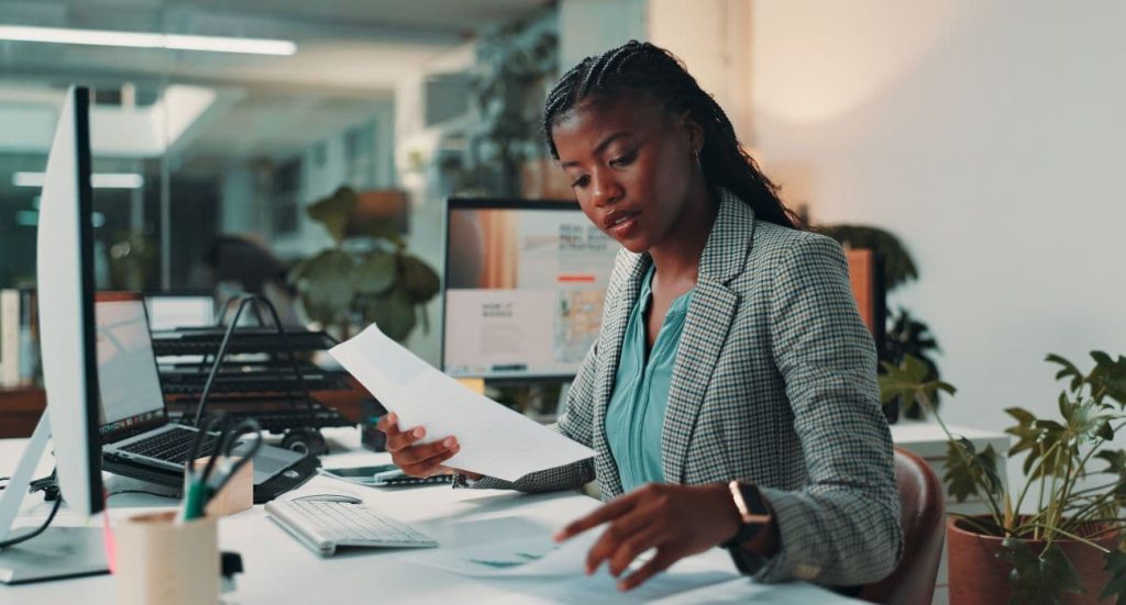 Mulher em sua mesa do escritório fazendo precificação inteligente