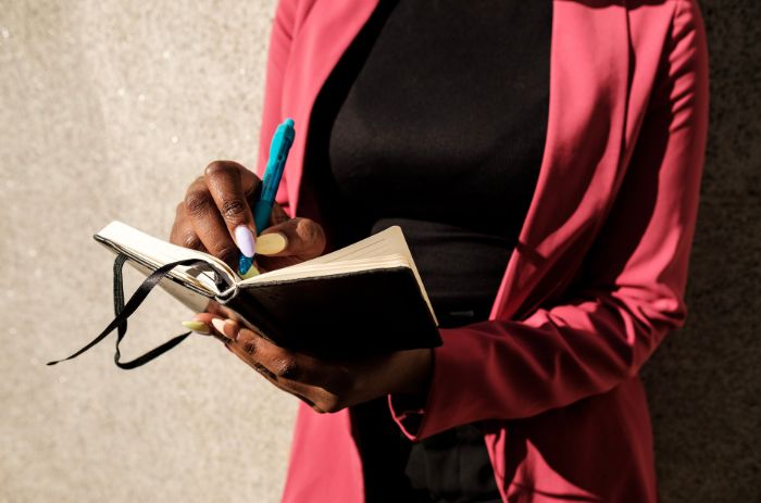 Mulher organizando rotina em sua agenda.