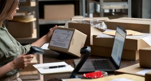 Mulher catalogando produto para enviar pela transportadora.