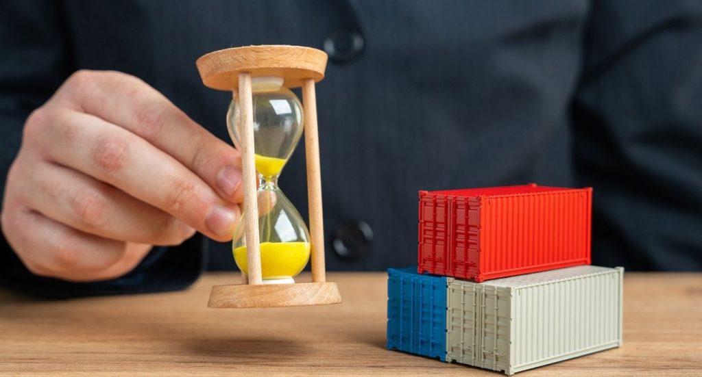 Homem segurando uma ampulheta ao lado de pequenos conteineres.